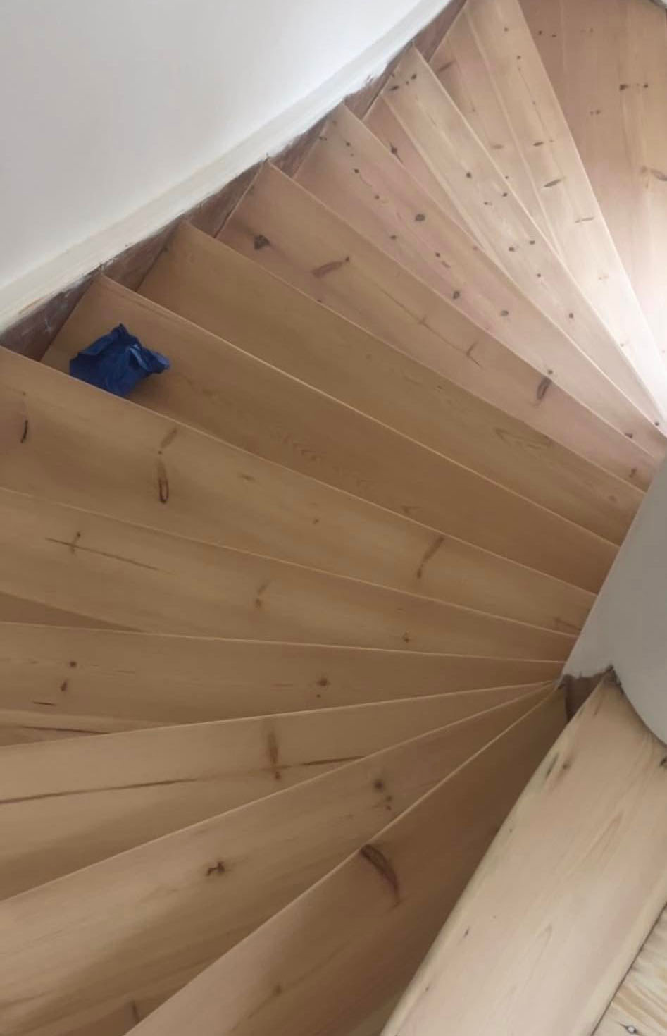 Efter-billede af den samme svingtrappe, som nu er smukt nyslebet og fremstår lys og ren efter professionel slibning af trappe.